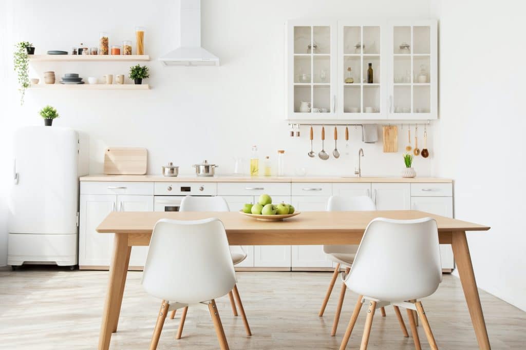 Minimalist scandinavian style. Dining room and light kitchen design with wooden table and white